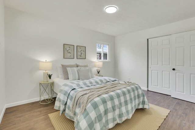 bedroom featuring a closet, baseboards, and wood finished floors
