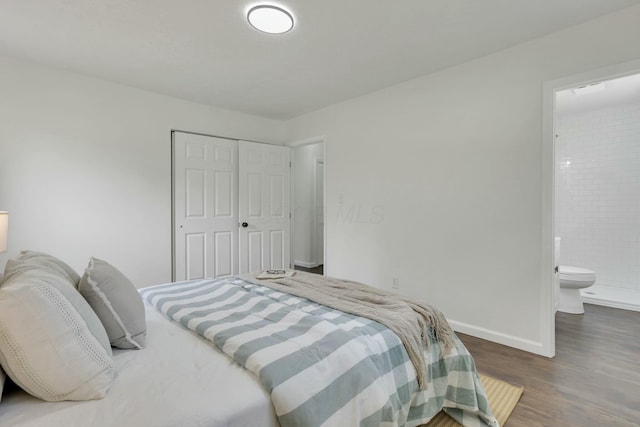 bedroom with a closet, baseboards, connected bathroom, and wood finished floors