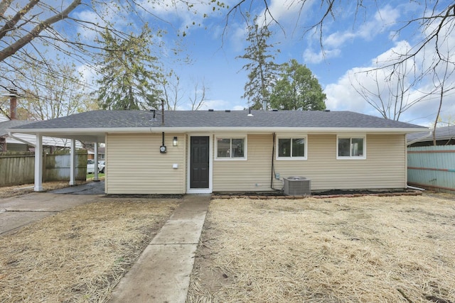 rear view of house featuring central AC, fence, and driveway