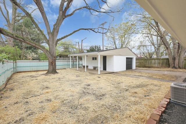 view of yard featuring driveway, cooling unit, a patio area, a fenced backyard, and a garage