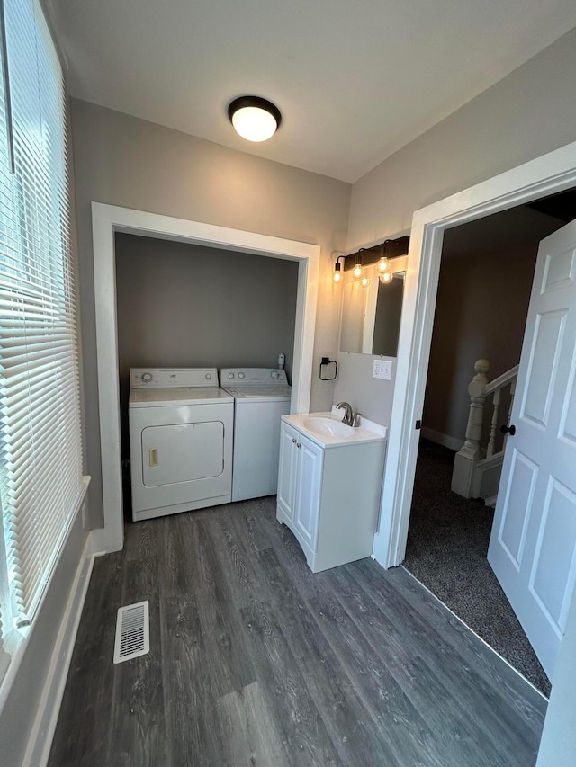 laundry room with separate washer and dryer, visible vents, laundry area, dark wood finished floors, and a sink