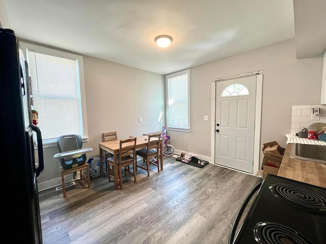 dining area with baseboards and wood finished floors