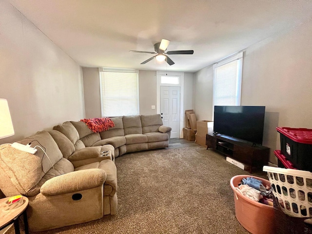 carpeted living area with a ceiling fan