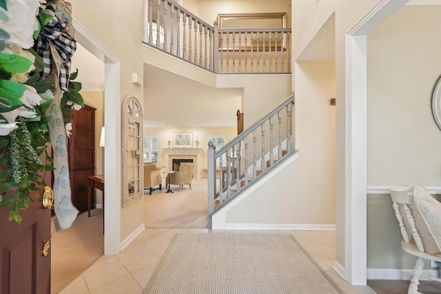 6690 Hermitage Dr, Westerville, OH 43082 - tiled foyer featuring carpet, a high ceiling, baseboards, a fireplace, and stairs