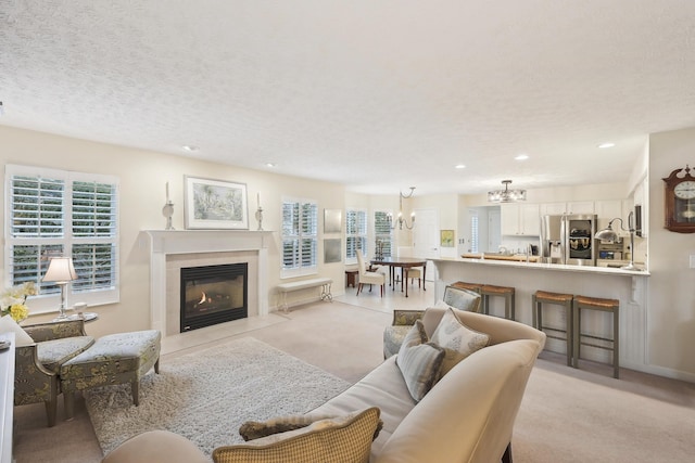 6690 Hermitage Dr, Westerville, OH 43082 - living room featuring recessed lighting, a tile fireplace, an inviting chandelier, light carpet, and a textured ceiling