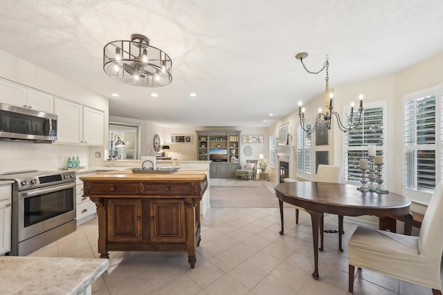 6690 Hermitage Dr, Westerville, OH 43082 - kitchen featuring a chandelier, appliances with stainless steel finishes, white cabinetry, and recessed lighting