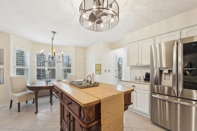 6690 Hermitage Dr, Westerville, OH 43082 - kitchen featuring white cabinets, stainless steel refrigerator with ice dispenser, a notable chandelier, and light tile patterned flooring