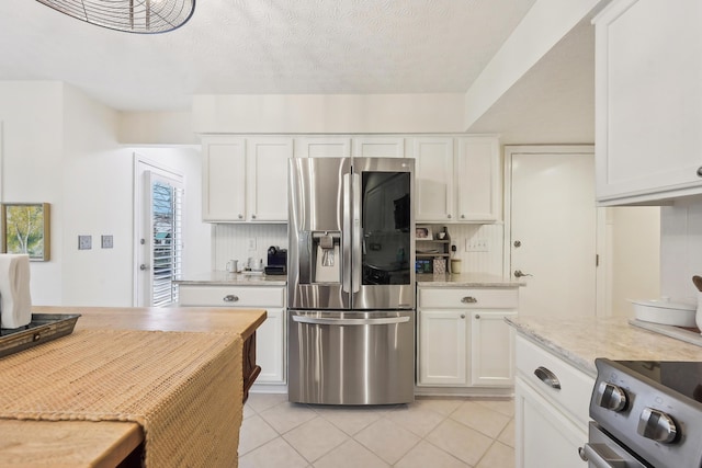 6690 Hermitage Dr, Westerville, OH 43082 - kitchen featuring light stone counters, appliances with stainless steel finishes, light tile patterned flooring, and white cabinetry