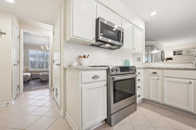 6690 Hermitage Dr, Westerville, OH 43082 - kitchen featuring light countertops, light tile patterned floors, white cabinetry, appliances with stainless steel finishes, and a notable chandelier