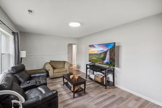 1779 Fairwood Ave, Columbus, OH 43207 - living room featuring visible vents, light wood-style flooring, arched walkways, and baseboards