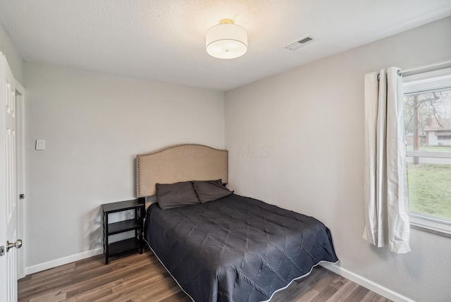 1779 Fairwood Ave, Columbus, OH 43207 - bedroom with visible vents, baseboards, multiple windows, and wood finished floors