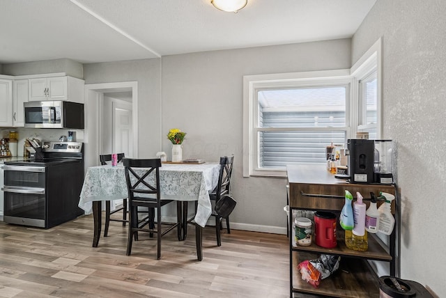 1779 Fairwood Ave, Columbus, OH 43207 - dining area with a textured wall, light wood-style flooring, and baseboards