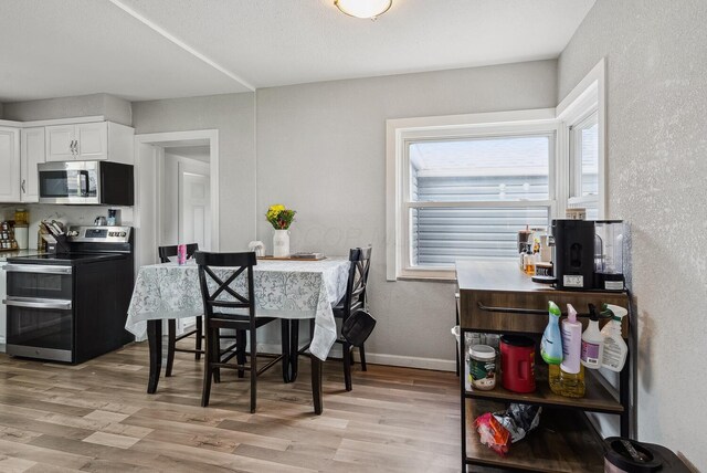 1779 Fairwood Ave, Columbus, OH 43207 - dining space with light wood-style floors, a textured wall, and baseboards