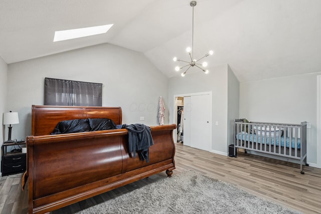 1779 Fairwood Ave, Columbus, OH 43207 - bedroom featuring vaulted ceiling with skylight, a closet, a chandelier, wood finished floors, and baseboards