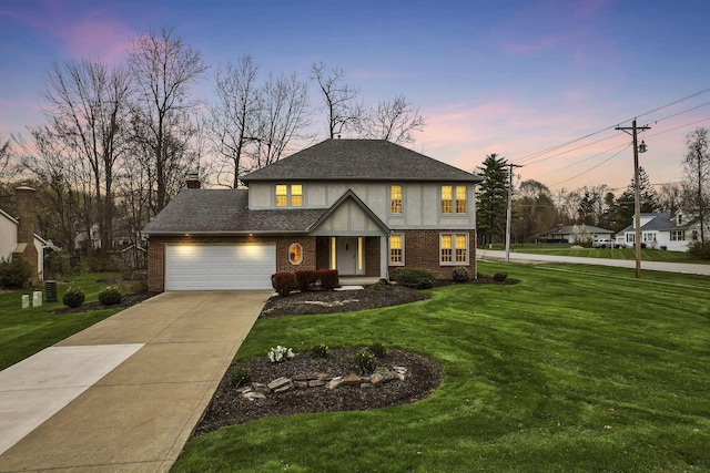 view of front facade featuring a shingled roof, an attached garage, brick siding, a front lawn, and driveway