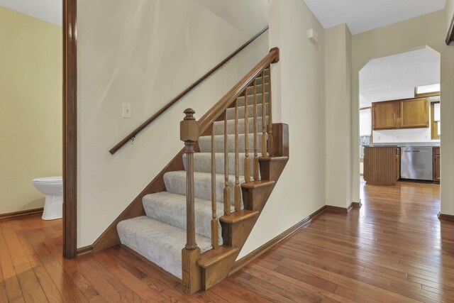 stairs featuring wood-type flooring and baseboards