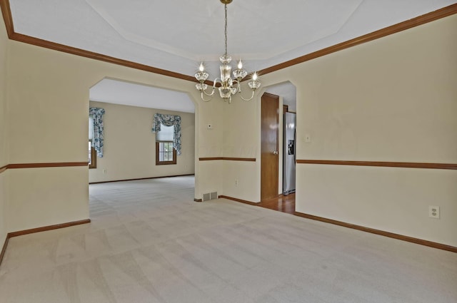 empty room featuring a notable chandelier, baseboards, carpet floors, visible vents, and arched walkways