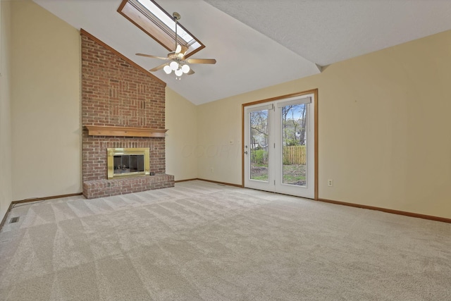 unfurnished living room featuring ceiling fan, a fireplace, vaulted ceiling, carpet floors, and baseboards