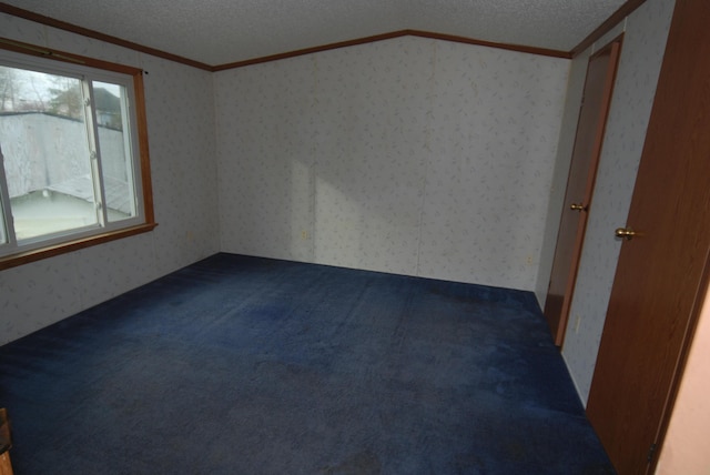 20543 Treaty Line Rd, West Mansfield, OH 43358 - spare room featuring wallpapered walls, dark colored carpet, a textured ceiling, and ornamental molding