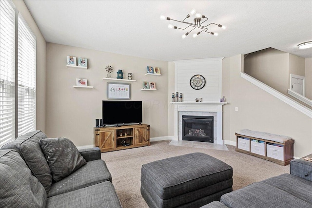 living area featuring baseboards, a premium fireplace, a chandelier, and light colored carpet