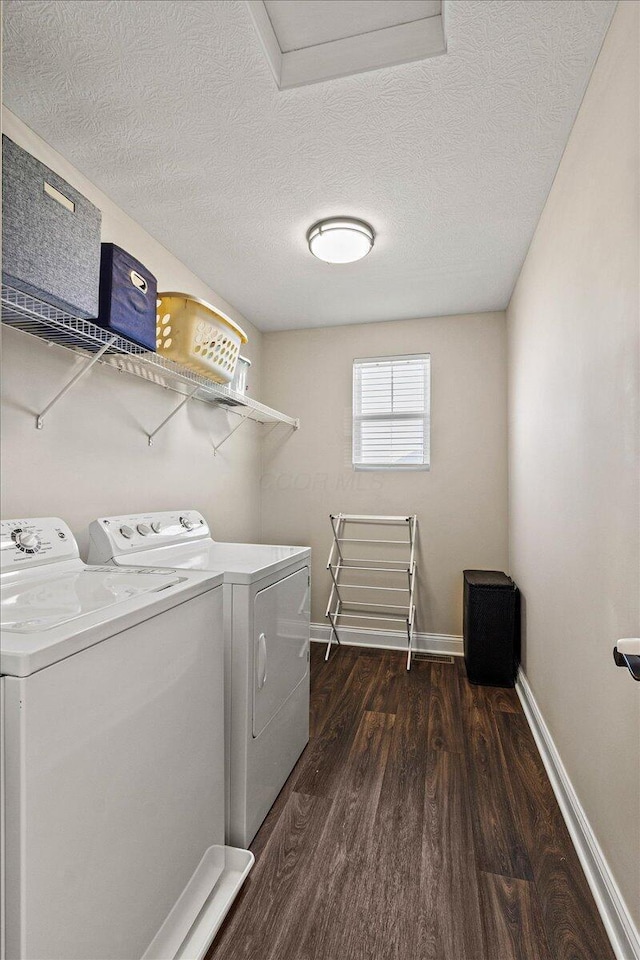 washroom with laundry area, a textured ceiling, baseboards, dark wood-style floors, and separate washer and dryer