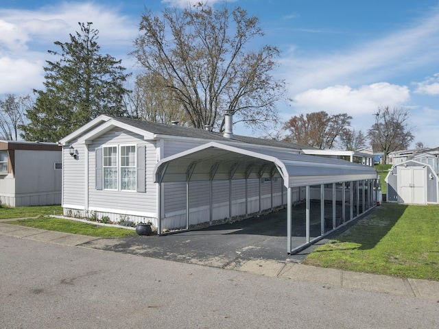 2445 Columbus Lancaster Rd NW Unit 147, Lancaster, OH 43130 - view of vehicle parking with a detached carport, a storage unit, and driveway