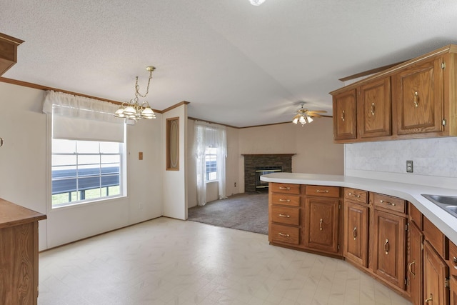 2445 Columbus Lancaster Rd NW Unit 147, Lancaster, OH 43130 - kitchen with brown cabinetry, a wealth of natural light, and ceiling fan with notable chandelier