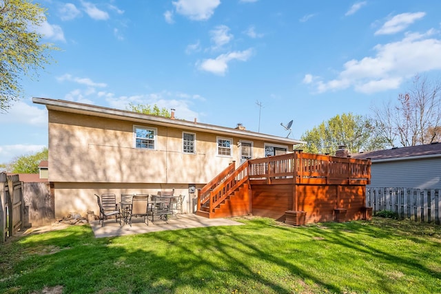 back of house with a fenced backyard, a deck, a patio, and stucco siding