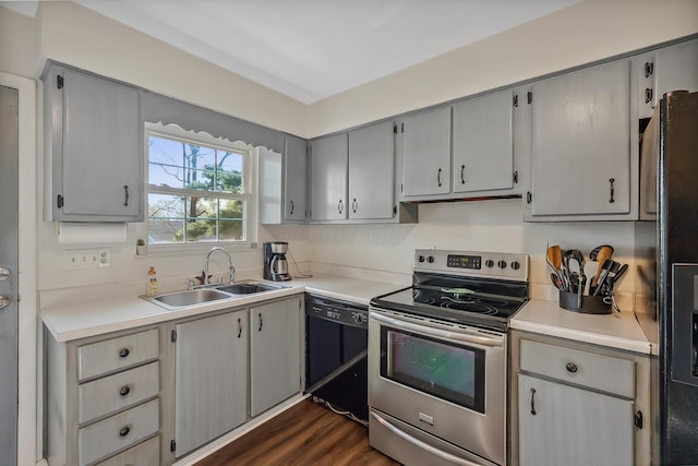 kitchen featuring light countertops, a sink, dark wood-type flooring, gray cabinetry, and black appliances
