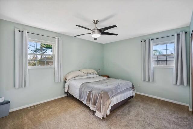 bedroom with visible vents, carpet flooring, baseboards, and multiple windows