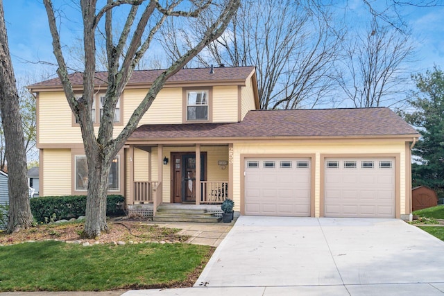 traditional-style home with a garage, driveway, a shingled roof, and covered porch