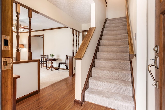 stairway with wood finished floors and baseboards