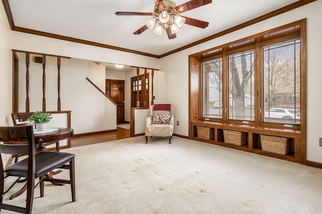 sitting room with ornamental molding, carpet floors, baseboards, and ceiling fan