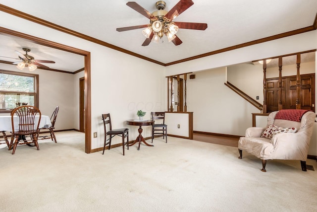 living area featuring carpet, baseboards, a ceiling fan, and crown molding