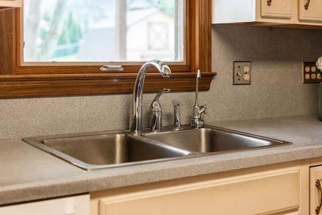 interior details featuring white cabinets, dishwasher, a sink, light countertops, and decorative backsplash