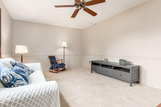 sitting room featuring carpet, wainscoting, and ceiling fan