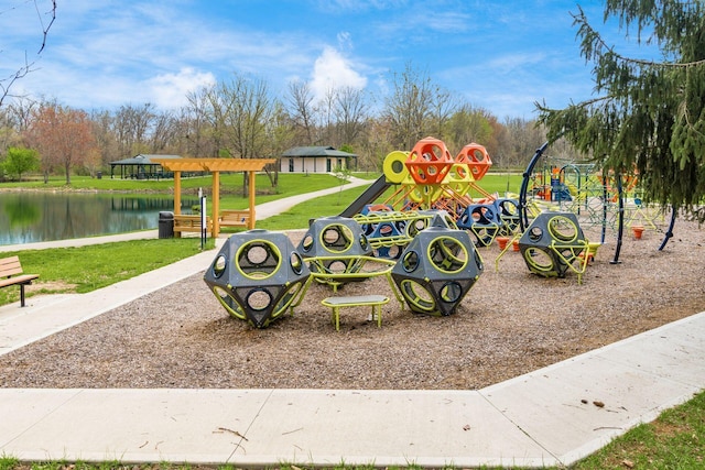communal playground featuring a water view and a lawn