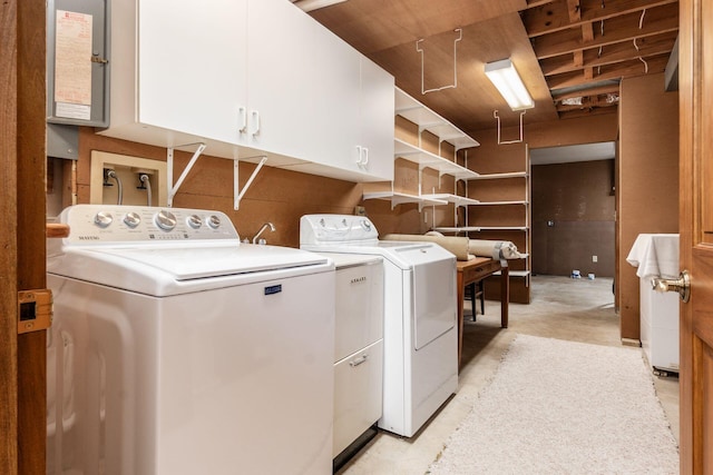 clothes washing area with independent washer and dryer and cabinet space