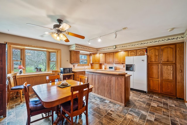 dining space with rail lighting, a toaster, and a ceiling fan