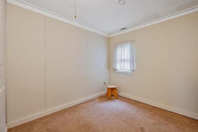 carpeted spare room with visible vents, baseboards, and ornamental molding