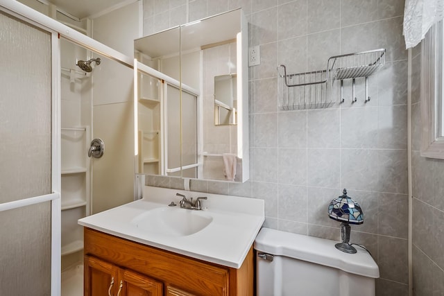 bathroom with tile walls, a shower stall, and vanity