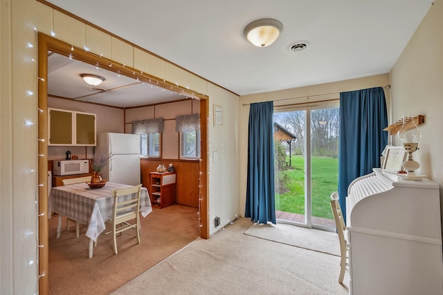 carpeted dining area featuring visible vents