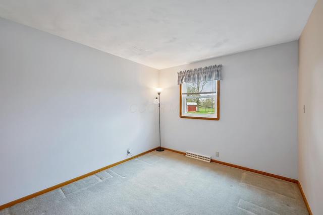spare room featuring carpet flooring, baseboards, and visible vents