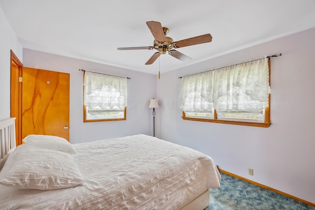 carpeted bedroom featuring baseboards and ceiling fan