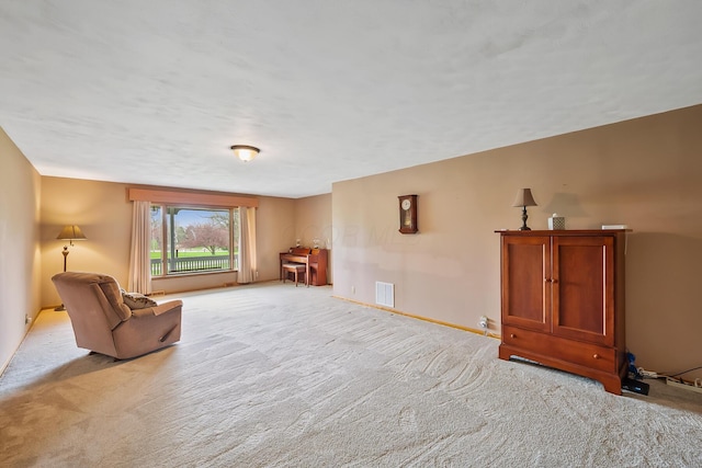 unfurnished room featuring visible vents, light colored carpet, and baseboards