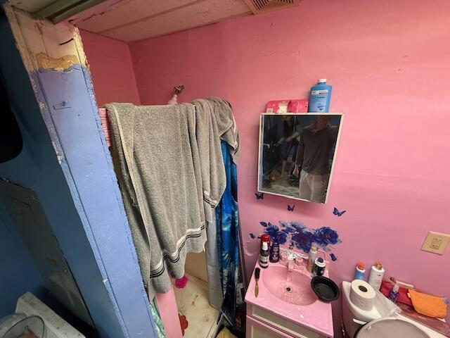 bathroom with vanity, curtained shower, and visible vents