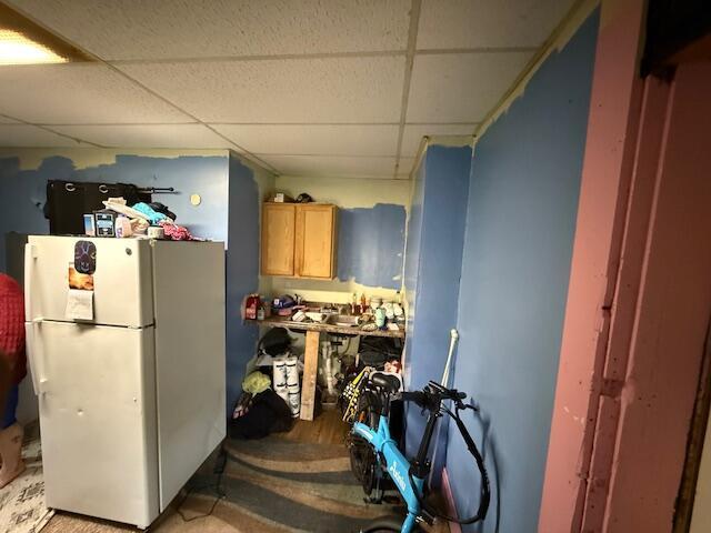kitchen with freestanding refrigerator and a paneled ceiling