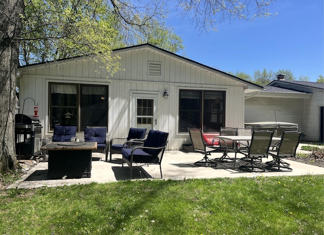 rear view of house with a lawn, an outdoor living space with a fire pit, and a patio