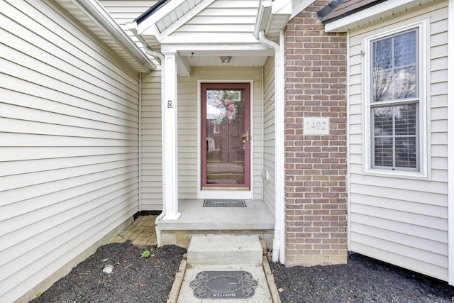 doorway to property with brick siding