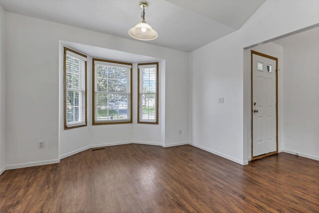 spare room featuring baseboards, visible vents, and dark wood-style flooring